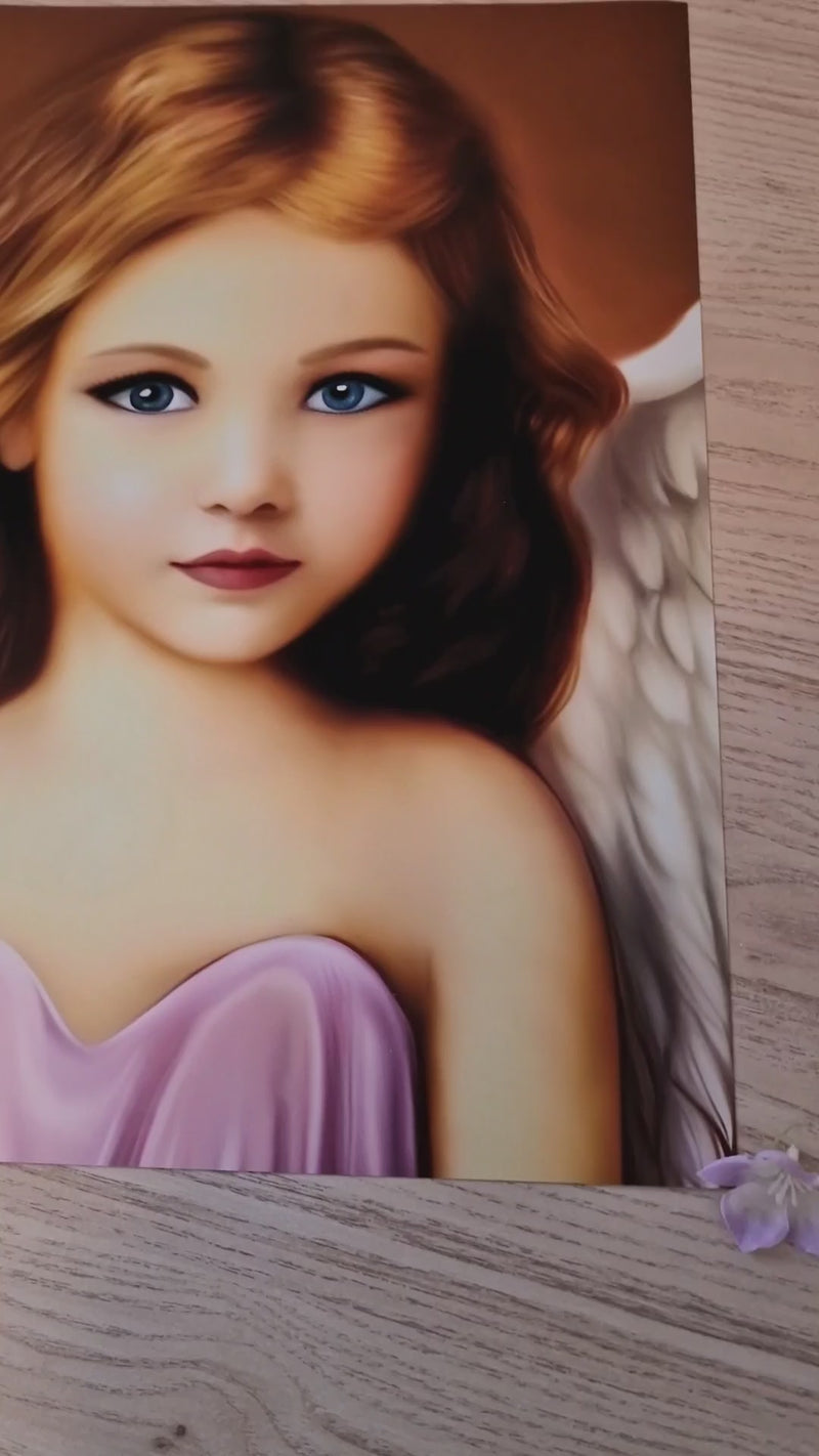 Video van een digitale artprint van een engeltje met goudblond haar en diepblauwe ogen. Het engeltje straalt warmte, liefde en zachtheid uit, met fijne details en zachte kleuren die een gevoel van troost, bescherming en rust oproepen. De camera beweegt langzaam over het kunstwerk en laat de levendige kleuren en de zijdeglans van het Photo Paper Luster Pro duidelijk zien.